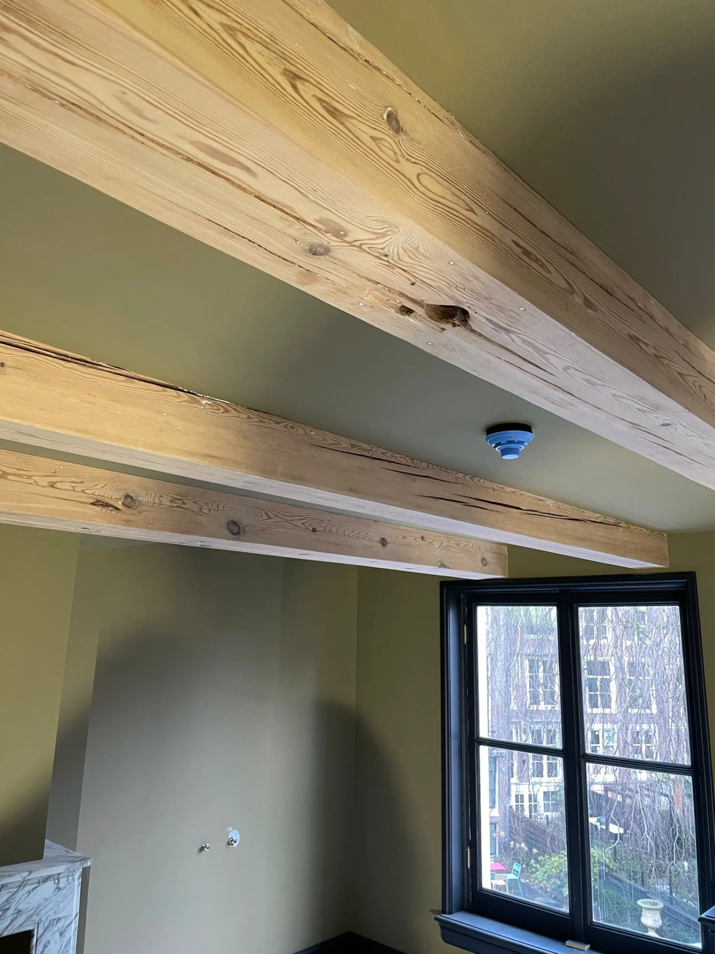 Geschilderde wanden en plafond rondom de bestaande houten balken, met schouw