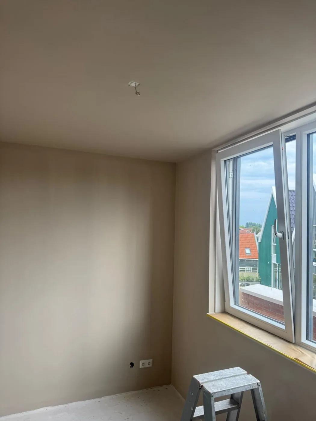 Wit gelakt kozijn in een slaapkamer in taupe