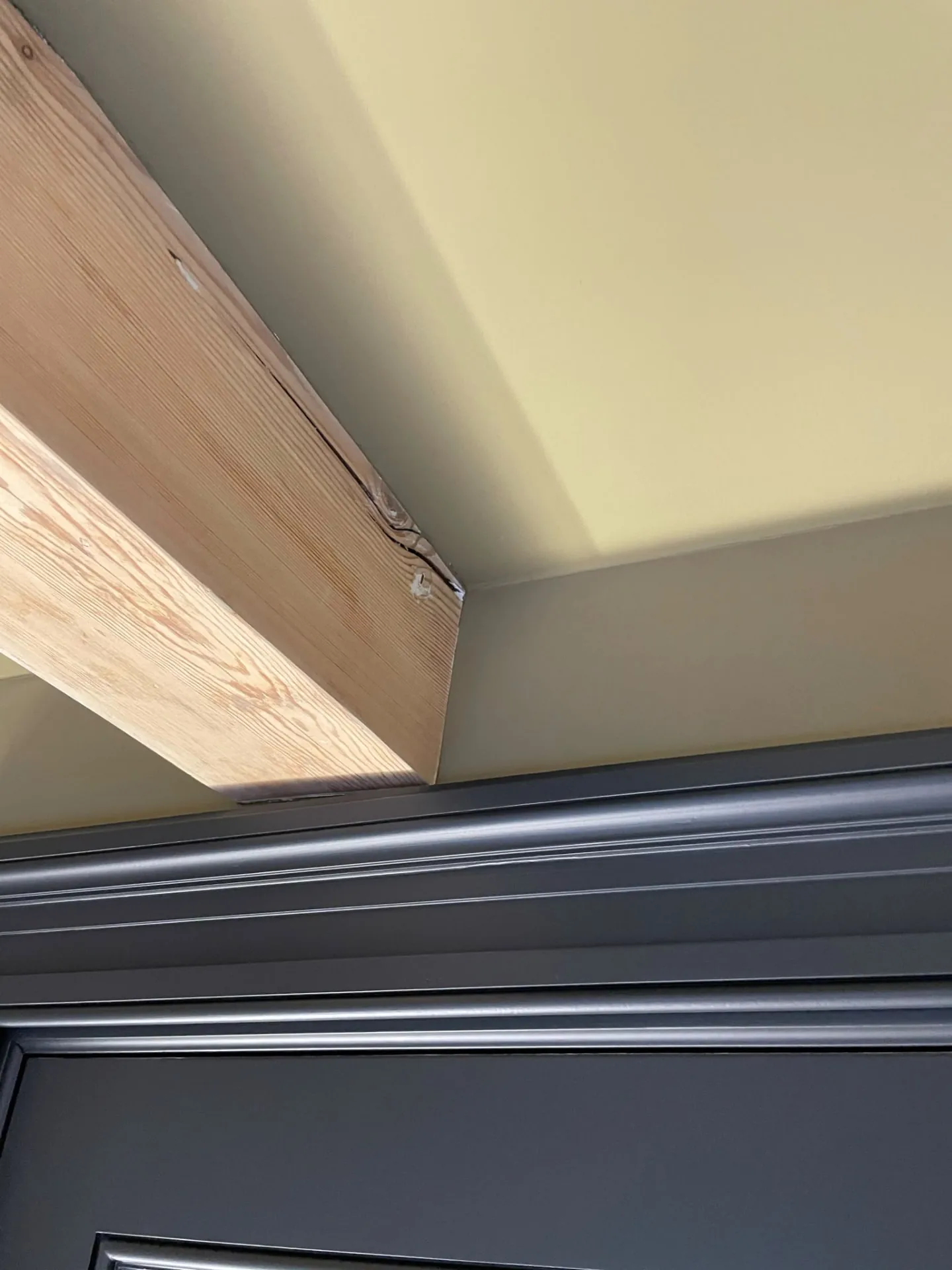 Deurkozijn strak afgewerkt tot tegen een onbehandelde houten balk