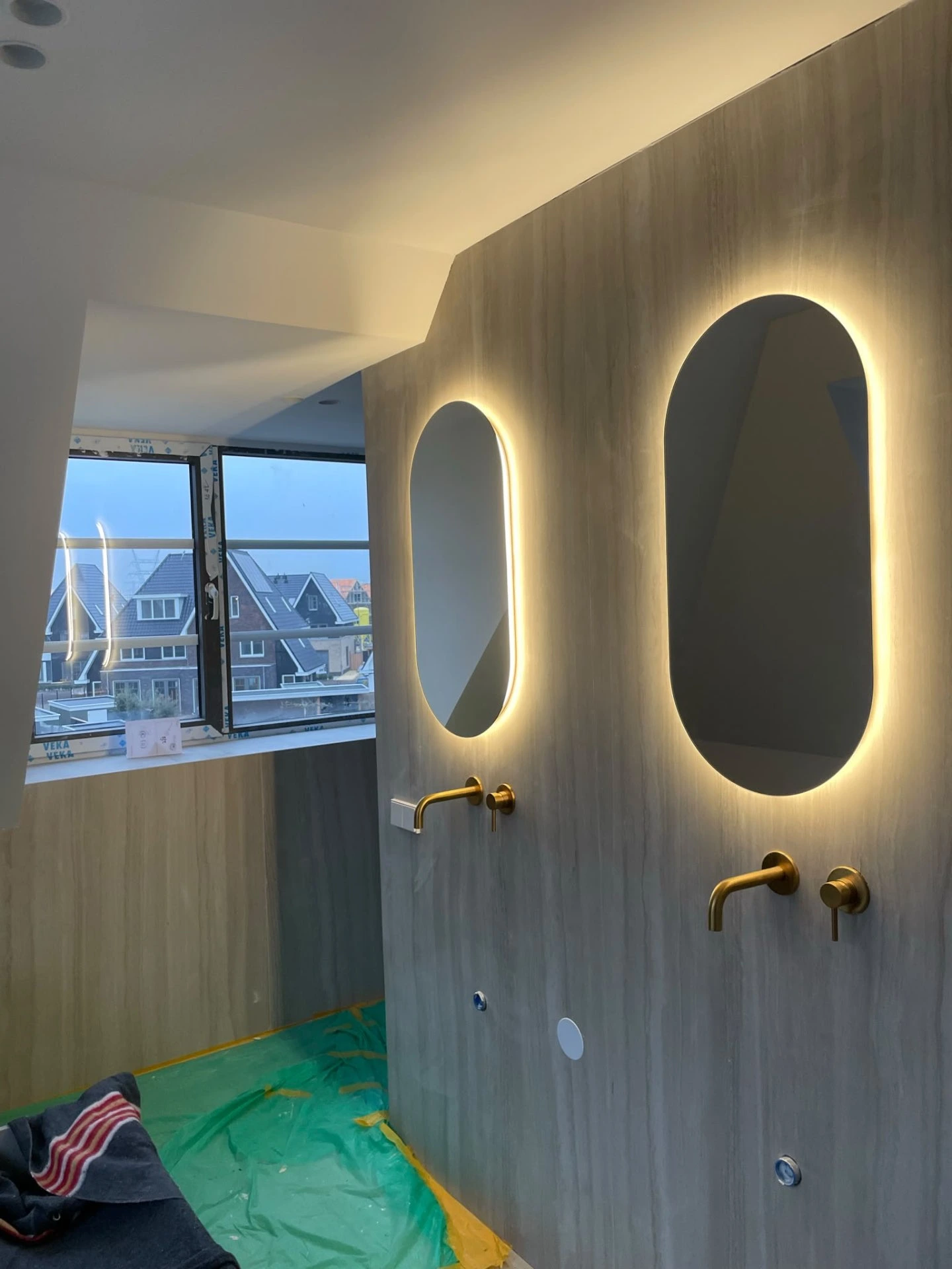Badkamerwand en plafond strak afgewerkt in een lichte tint