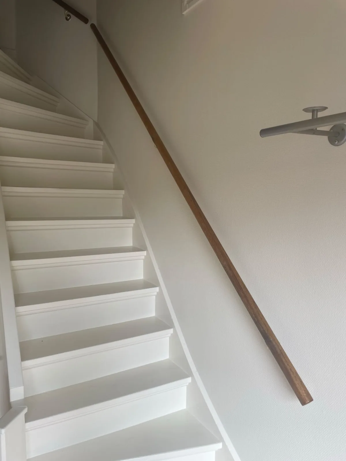 Wit gelakte trap met houten leuning